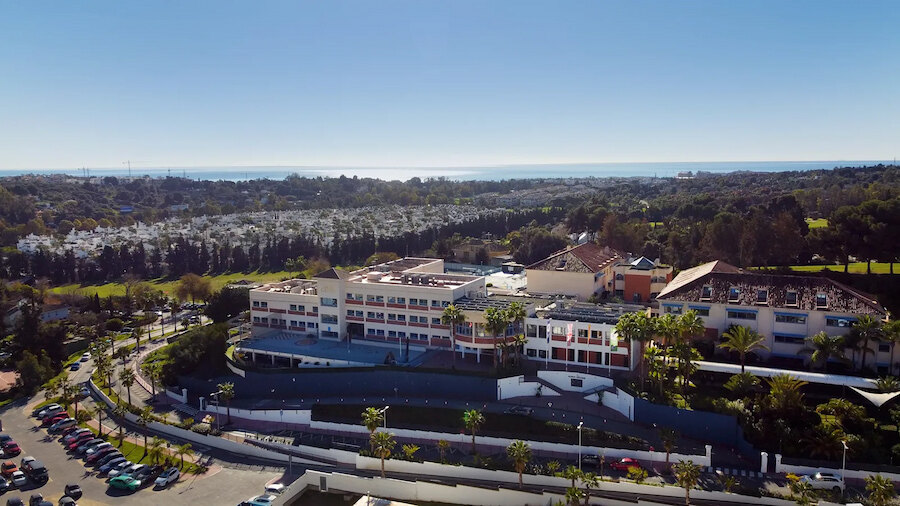 International school campus in Marbella surrounded by greenery with the Mediterranean Sea in the background
