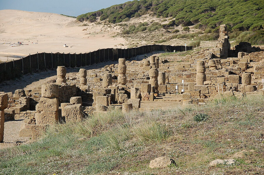 Ruinas de piedra junto a dunas costeras, revelando vestigios de la historia antigua de Marbella.