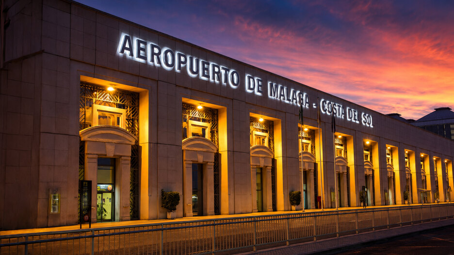Außenansicht des Flughafens Málaga und Immobilienkäufer in Marbella bei der Ankunft an der Costa del Sol bei Sonnenuntergang.