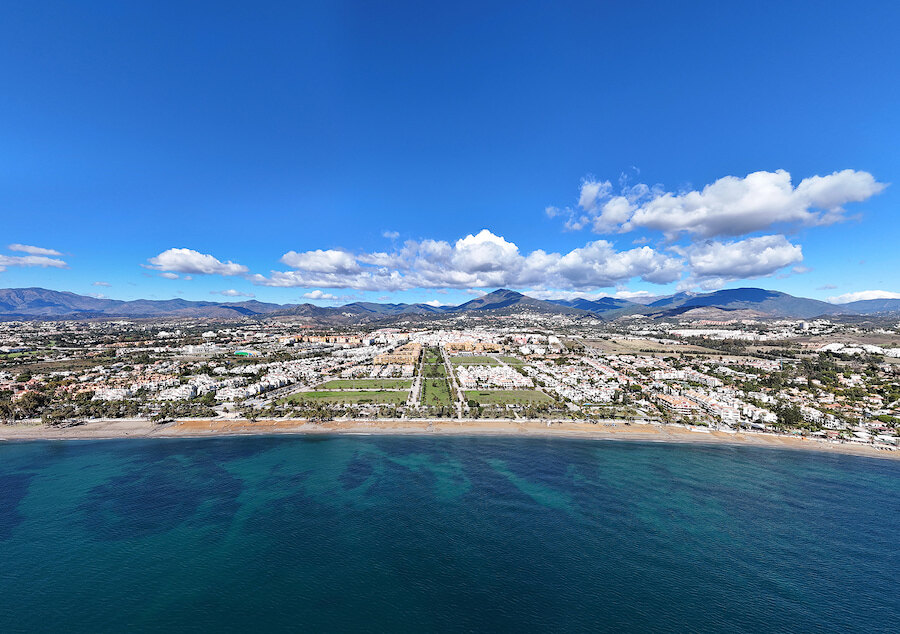 Aerial view of San Pedro de Alcántara beachfront, showing the coastline, residential area and surrounding mountains.