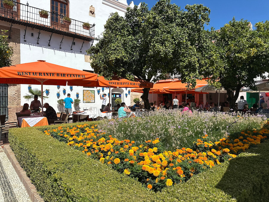 Restaurant terraces and flower gardens in Plaza de los Naranjos, one of the best-known Marbella attractions