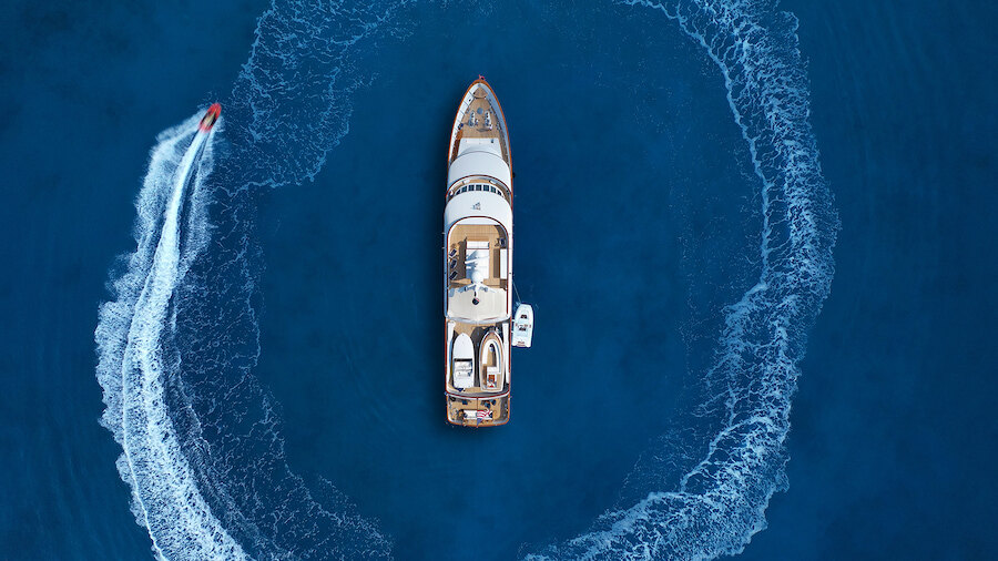 Aerial view of a yacht cruising through deep blue waters near Marbella
