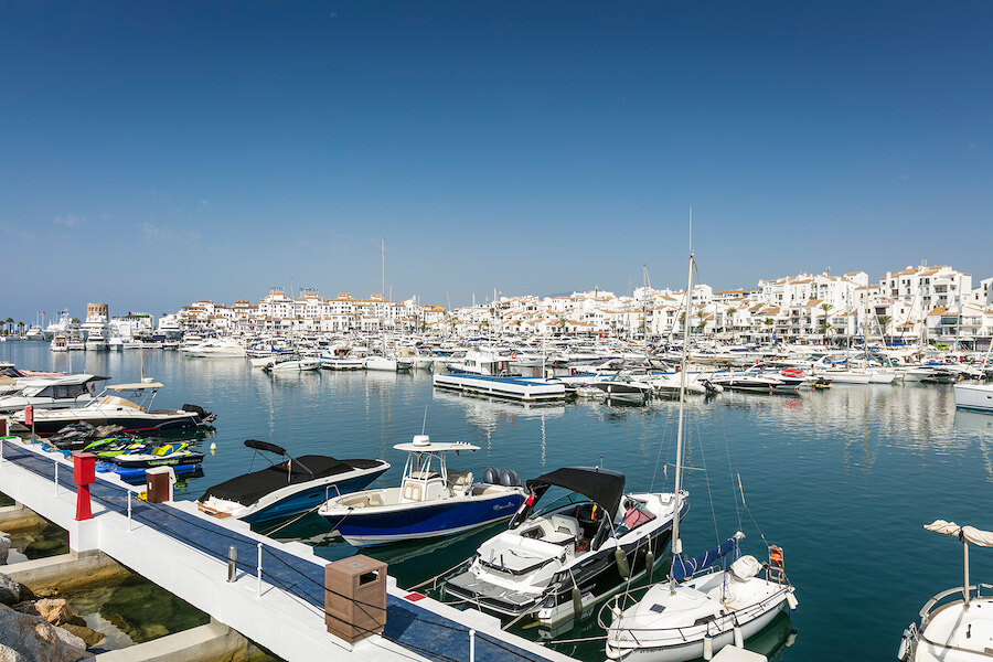 Boote im Yachthafen von Puerto Banús vor weißen Ufergebäuden und dem ruhigen Wasser des Mittelmeers