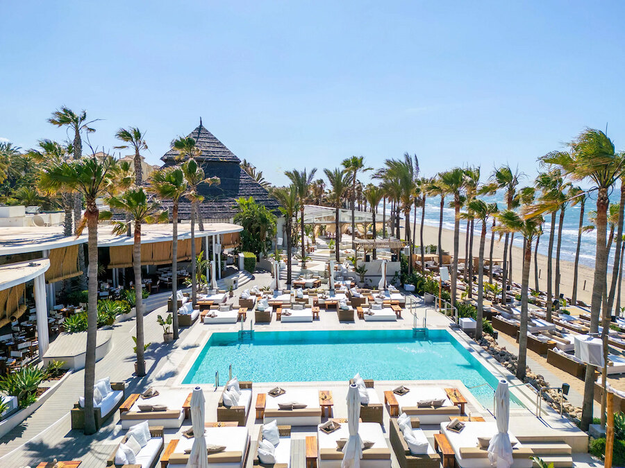 Luxury beach clubs in Marbella East with pool, sunbeds, palm trees and direct views of the beach