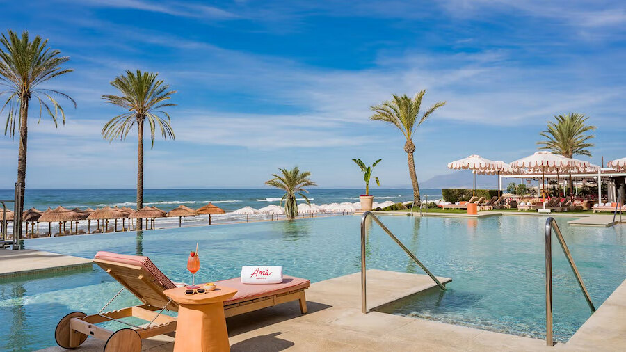 Beach clubs in Marbella with infinity pool, sea views, palm trees and sunbeds overlooking the Mediterranean