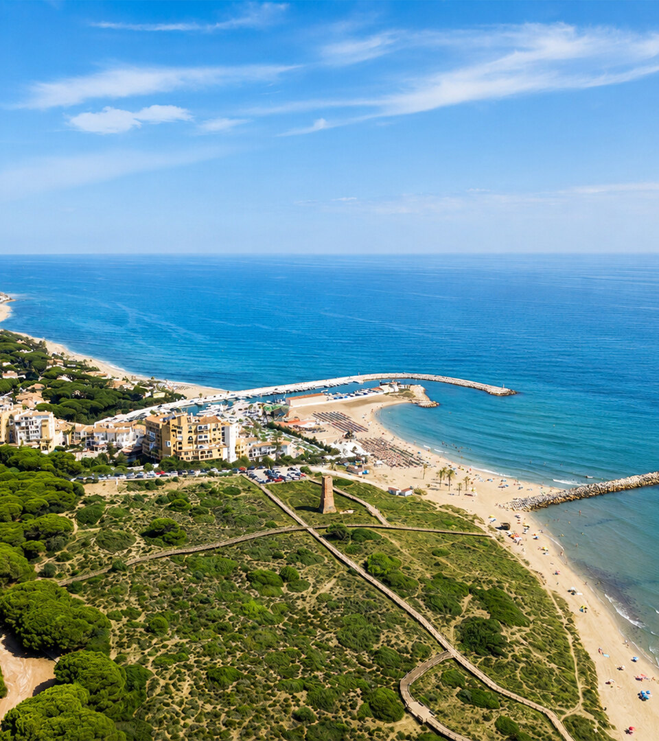 Aerial view of Cabopino beach, marina and protected dunes along the Marbella East coast