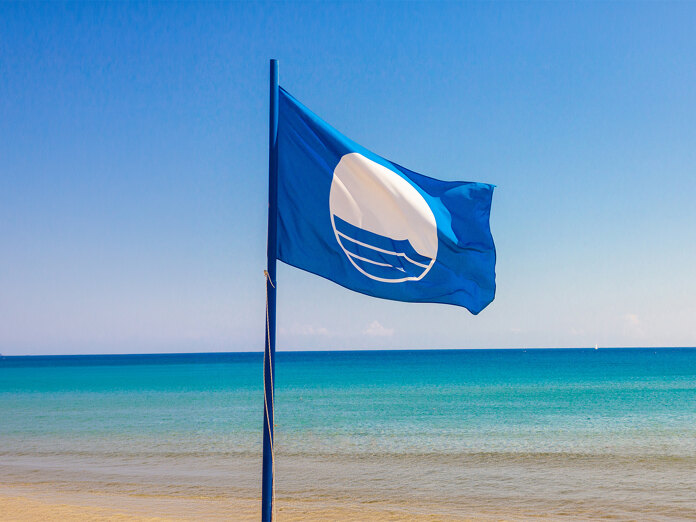 Pavillon Bleu flottant au bord de la mer, symbole de la qualité et de l’excellence des plages Pavillon Bleu à Málaga.