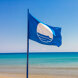 Bandera Azul ondeando junto al mar, simbolizando la calidad y la excelencia de las playas con Bandera Azul en Málaga.