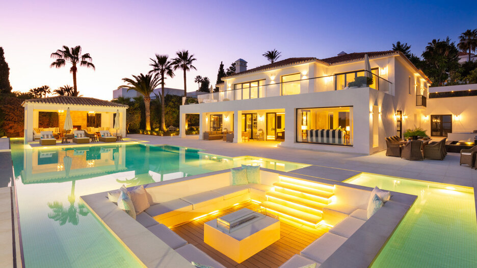 Villen zum Verkauf in Südspanien mit beleuchtetem Pool, Outdoor-Lounge und eleganter Abendterrasse.