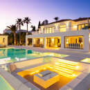 Villas en venta en el sur de España con una piscina iluminada, salón exterior y elegante terraza al atardecer.