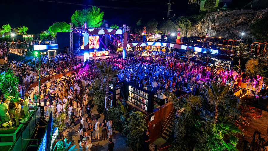 A large crowd enjoying the Starlite Marbella 2026 festival at night with a brightly lit outdoor stage.