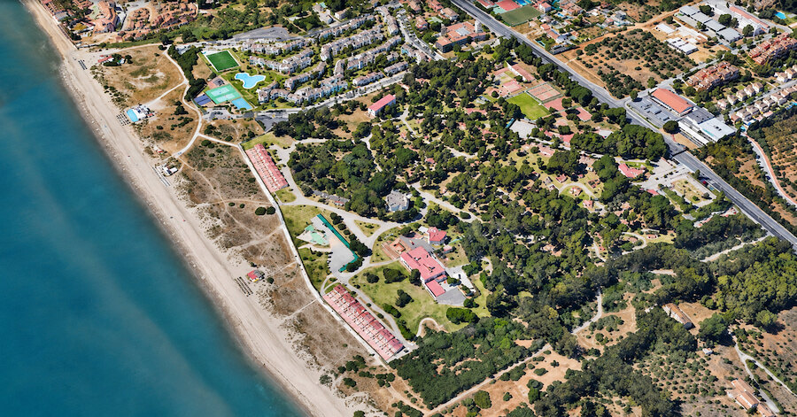 Aerial view of beachfront land and residential areas highlighting Marbella East resort investment potential