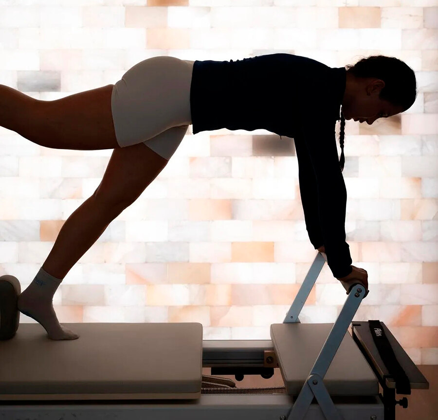 Pilates-Reformer-Session in einem stilvollen Studio, inspiriert von Marbellas Luxus-Fitnessstudios.