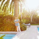 Property investment in Marbella shown through a couple enjoying a luxury garden and pool setting