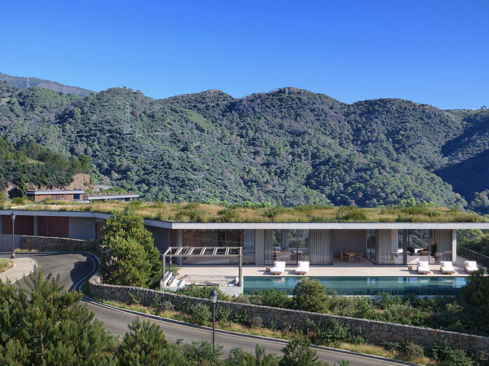 Single-storey modern villa with green roof and pool surrounded by mountains, showing the evolving design of Marbella