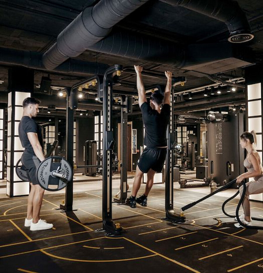 Personal-Training-Session in einem der Luxus-Fitnessstudios in Marbella mit Klimmzügen, Langhanteltraining und Konditionsübungen.