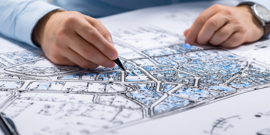 Plan d'urbanisme de Marbella. Gros plan d’un architecte ou d’un urbaniste annotant des détails sur un plan d’urbanisme à l’aide d’un stylo.