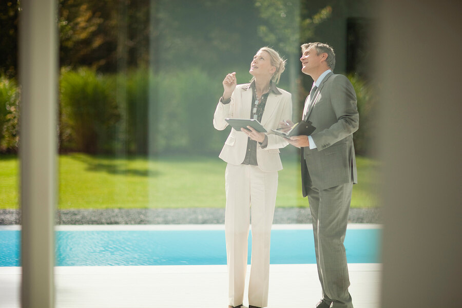 investissement immobilier à Marbella avec des conseillers immobiliers visitant une villa de luxe au bord de la piscine