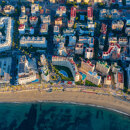 Vue aérienne du front de mer de Marbella, montrant des immeubles d’appartements en bord de mer, la promenade, la plage de sable et la mer Méditerranée.