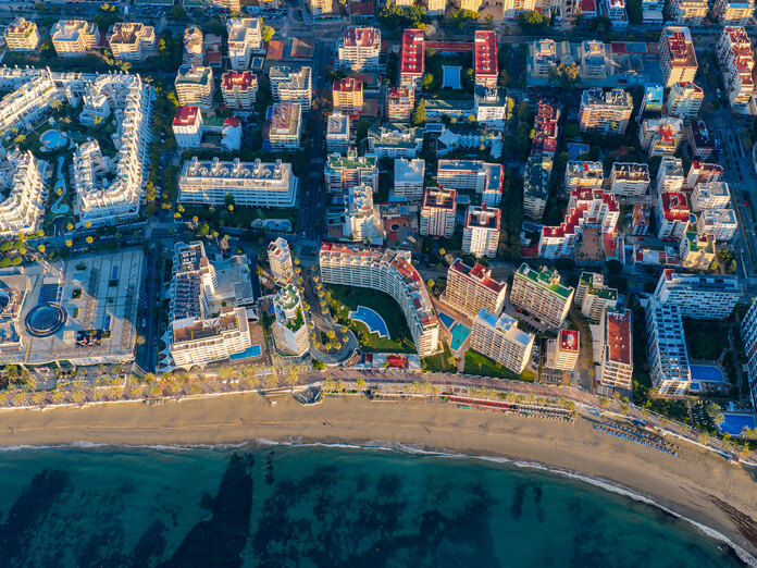 Luchtfoto van de kustlijn van Marbella, met appartementen aan zee, de promenade, het zandstrand en de Middellandse Zee.