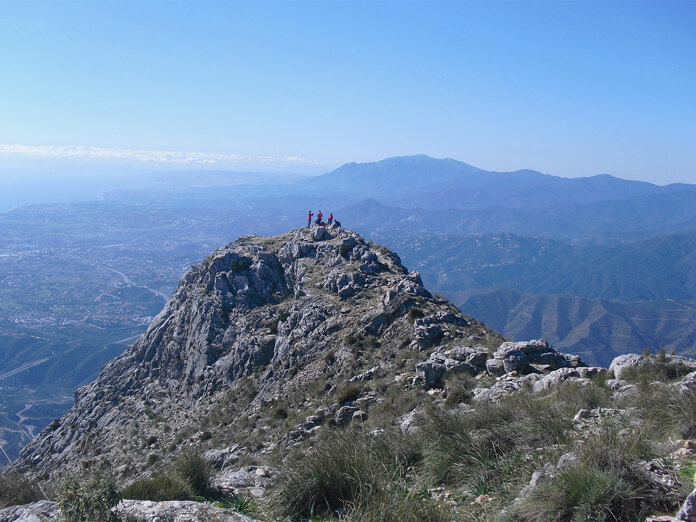 Des randonneurs se retrouvent au sommet rocheux de La Concha, dominant le paysage montagneux de Marbella.