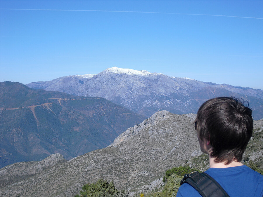 Wandelaars verzamelen zich op de rotsachtige top van La Concha boven het berglandschap van Marbella.