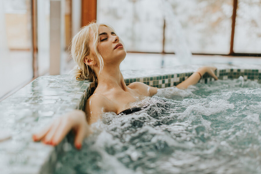 Woman relaxing in a bubbling jacuzzi in a luxury Marbella villa with private spa