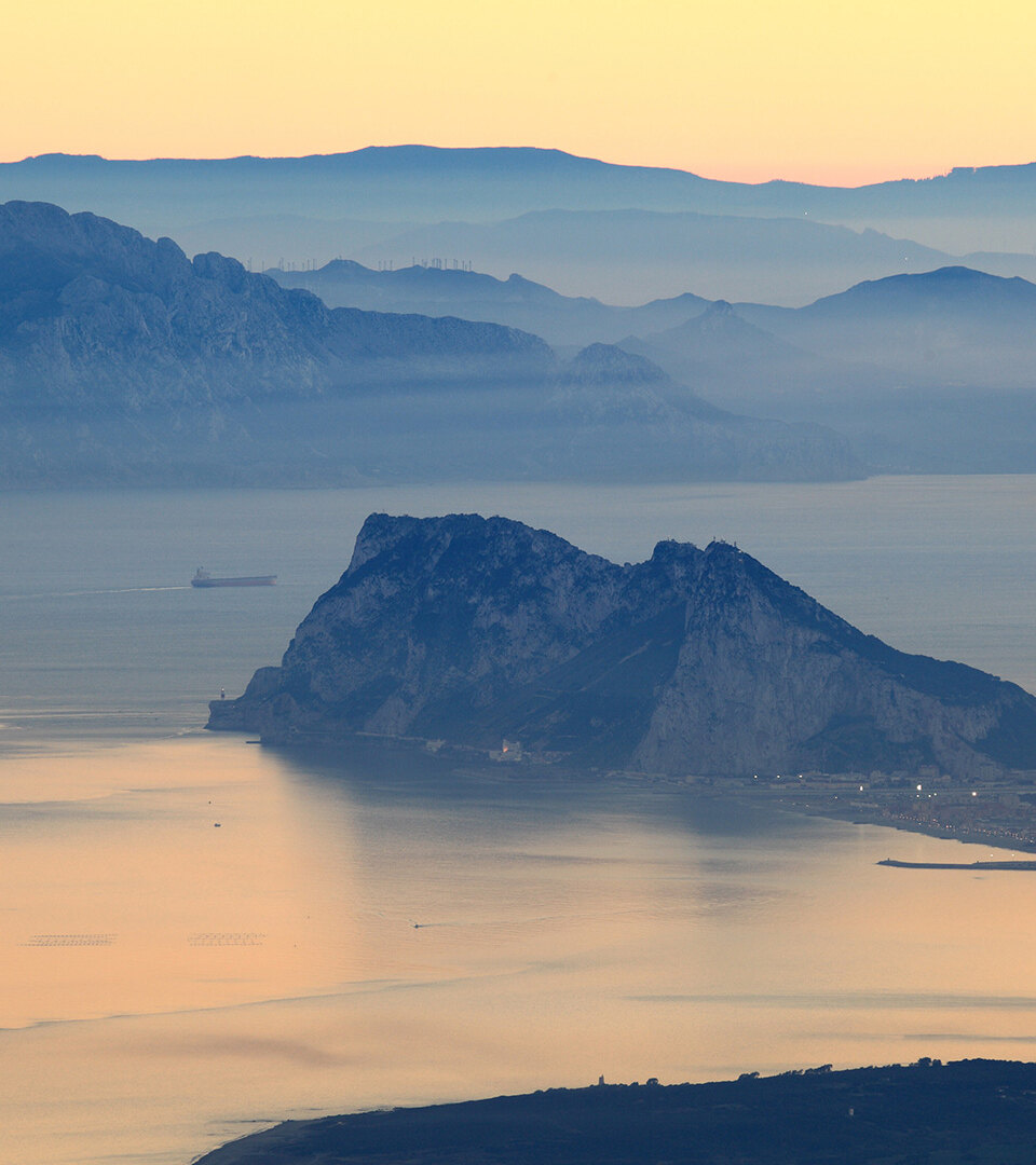 Vista panorámica del Peñón de Gibraltar al atardecer sobre la bahía, relacionada con el tratado de Gibraltar con España