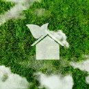 Aerial view of Europe formed in green grass, with a white eco-friendly house icon and soft clouds above, symbolising sustainable real estate and green housing.