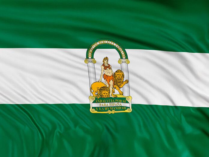 Drapeau de l’Andalousie composé de bandes horizontales vertes et blanches avec les armoiries régionales au centre, représentant Hercule entre deux lions sous une arche et l’inscription « Andalucía por sí, para España y la Humanidad.