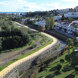 Aerial view of Marbella’s new riverside promenade, with a paved path, railings and nearby homes, and the Mediterranean Sea in the distance.