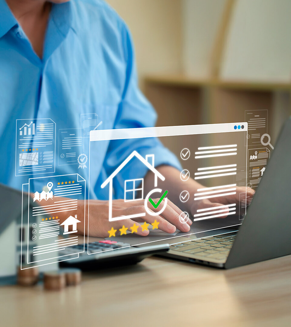 Persona utilizando un portátil para gestionar anuncios inmobiliarios, con iconos digitales del sector, valoraciones y el símbolo de una vivienda en pantalla, que representan la evaluación y gestión online de propiedades.