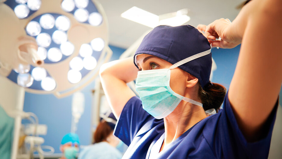 Healthcare on the Costa del Sol. Nurse putting on her mask in the operating theatre of a hospital on the Costa del Sol.