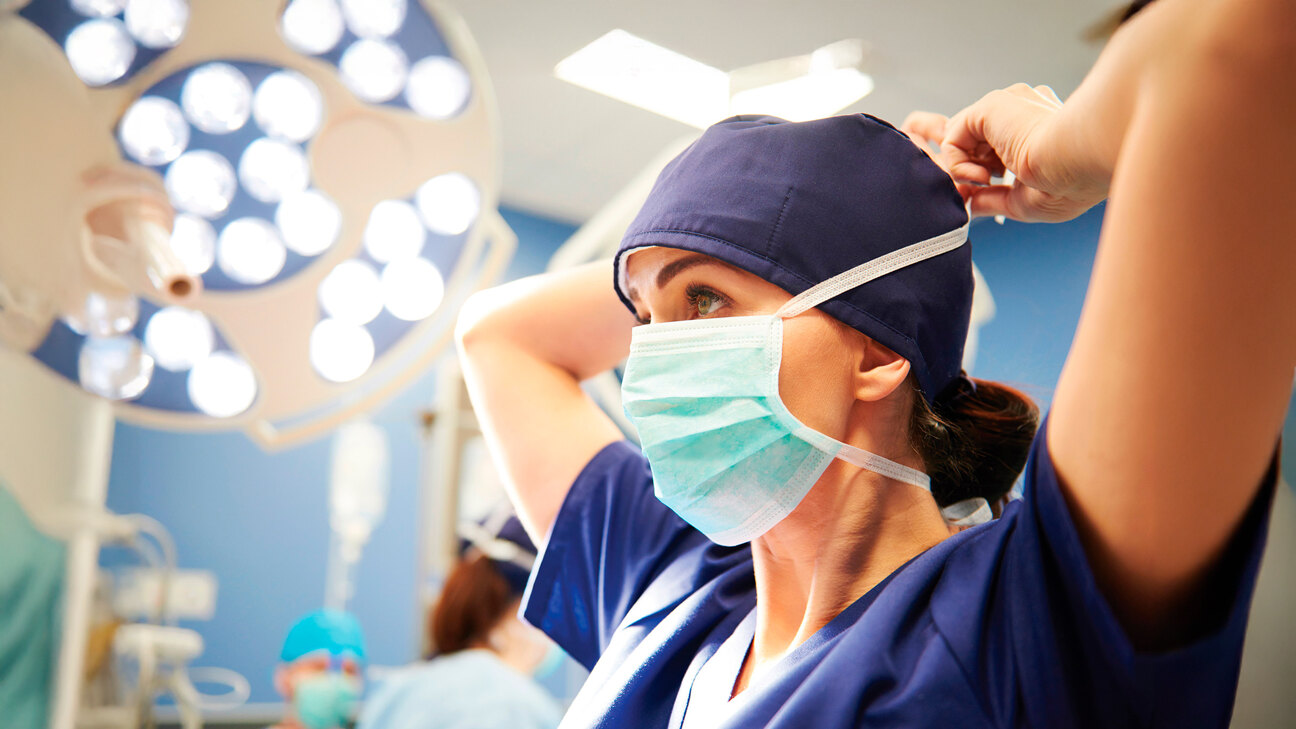 Hospitals in Marbella and the Costa del Sol Healthcare on the Costa del Sol. Nurse putting on her mask in the operating theatre of a hospital on the Costa del Sol.