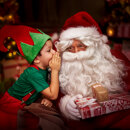 Smiling child dressed as an elf whispering a secret to Santa Claus while he holds wrapped Christmas presents.