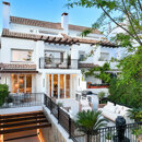 Vue extérieure de Casa Marisal, sur la Golden Mile de Marbella, avec sa façade blanche de style méditerranéen, ses terrasses aménagées avec des espaces de détente en plein air, sa végétation luxuriante et ses élégantes finitions contemporaines.
