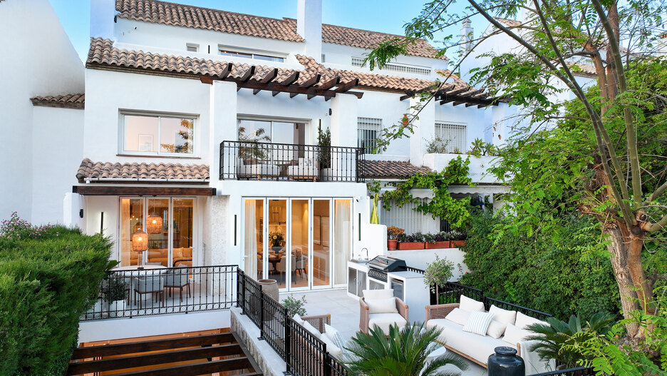 Exterior view of Casa Marisal on Marbella’s Golden Mile, showcasing its white Mediterranean-style façade, terraces with outdoor seating, lush greenery, and elegant contemporary finishes.