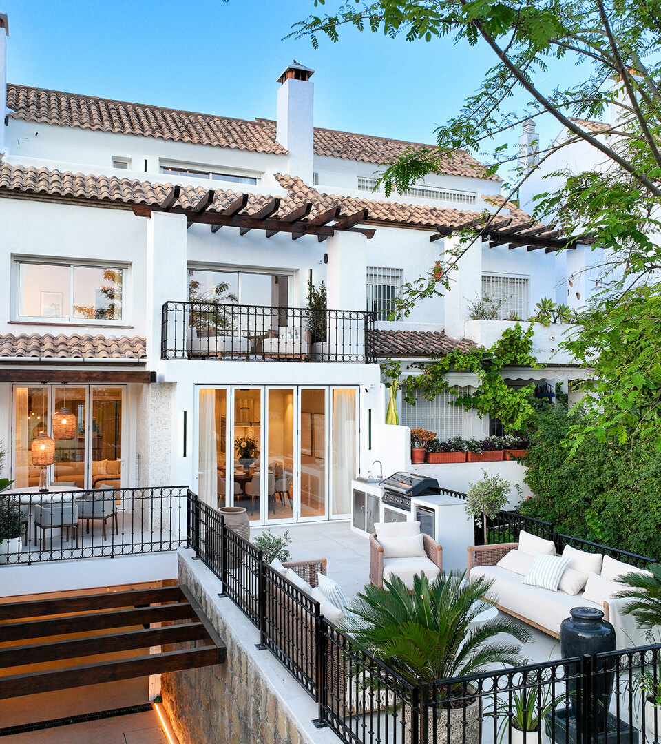 Exterior view of Casa Marisal on Marbella’s Golden Mile, showcasing its white Mediterranean-style façade, terraces with outdoor seating, lush greenery, and elegant contemporary finishes.