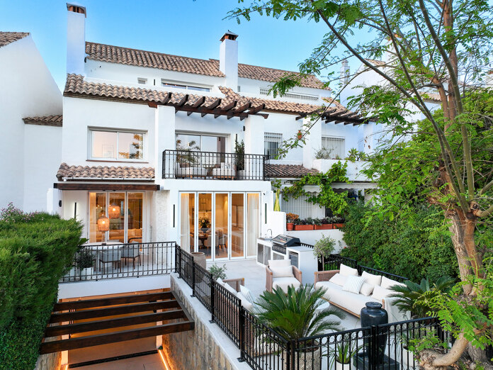 Exterior view of Casa Marisal on Marbella’s Golden Mile, showcasing its white Mediterranean-style façade, terraces with outdoor seating, lush greenery, and elegant contemporary finishes.