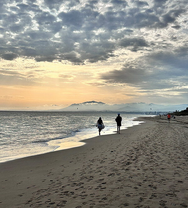 Couple walking along the shore of one of the beaches in Marbella