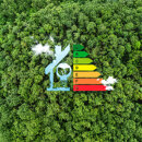 Energy efficiency rating chart from A to G shaped like a house, over a green forest background.