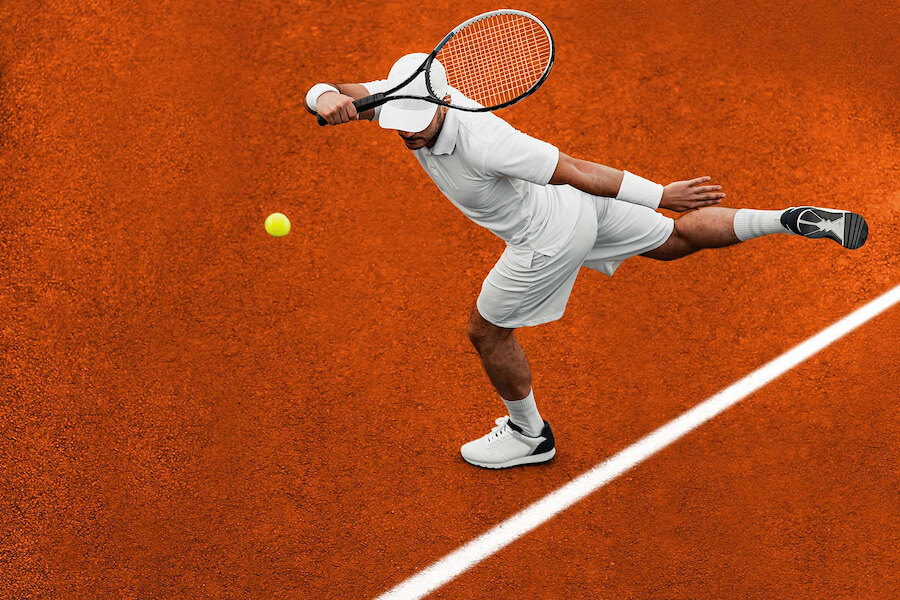 Een tennisser, geheel gekleed in het wit, serveert op een felrode gravelbaan. De actie is perfect in balans en geconcentreerd vastgelegd terwijl de bal van het racket afgaat.