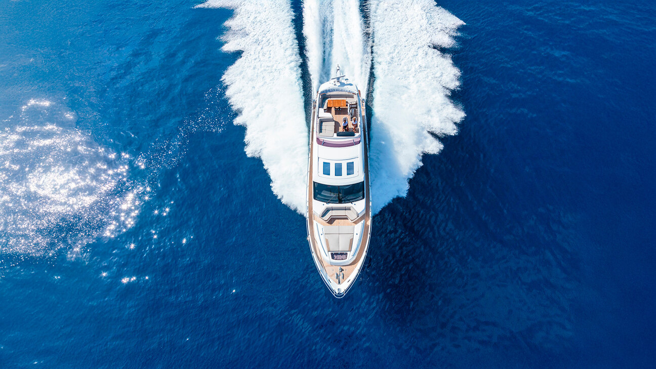 Location de yacht privé et voile à Marbella. Vue aérienne d'un yacht de luxe filant à travers les eaux bleues profondes de la Méditerranée, laissant une traînée blanche dans son sillage.