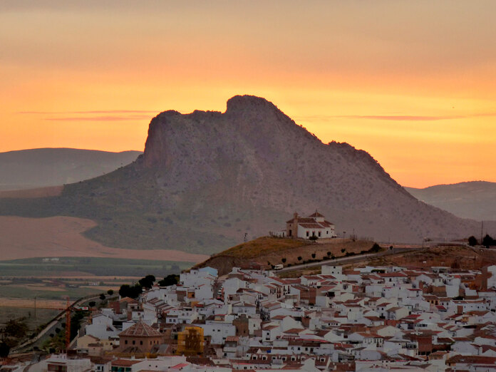 Sunset over the Peña de los Enamorados in Antequera, with the rock’s human-face profile and the whitewashed town in the foreground.