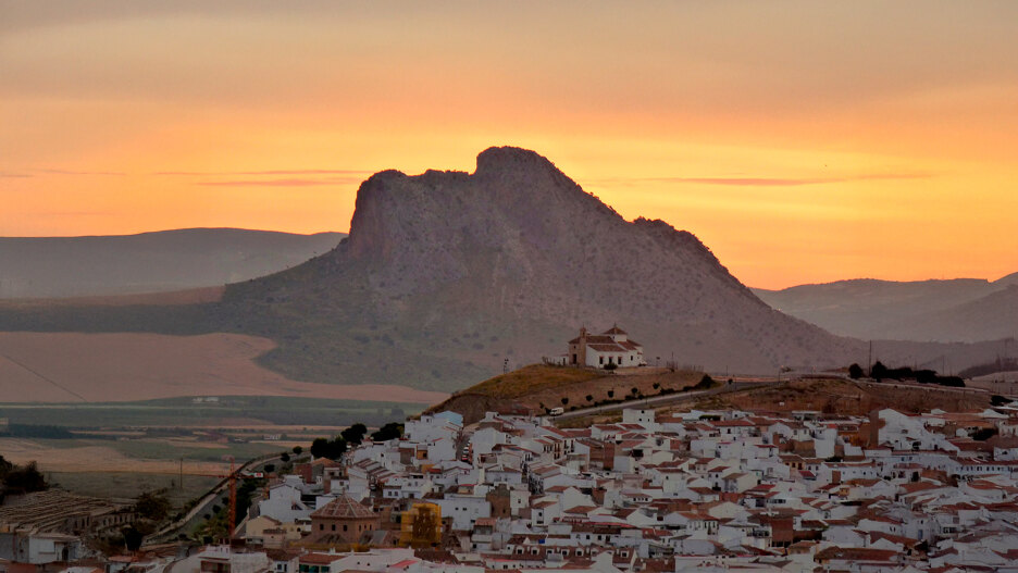 Sunset over the Peña de los Enamorados in Antequera, with the rock’s human-face profile and the whitewashed town in the foreground.