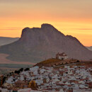 Sunset over the Peña de los Enamorados in Antequera, with the rock’s human-face profile and the whitewashed town in the foreground.