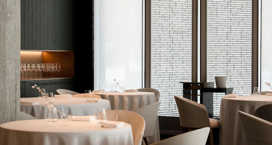 Messina Restaurant: The image shows the dining room of the Messina Restaurant with round tables dressed with white tablecloths, modern chairs, and carefully arranged glassware.