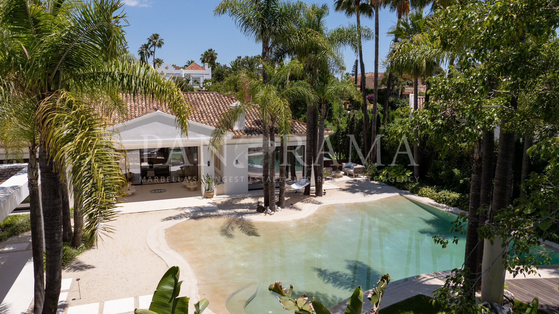 Modern new villa with sleek architecture and a unique natural pool with sand in Nueva Andalucía